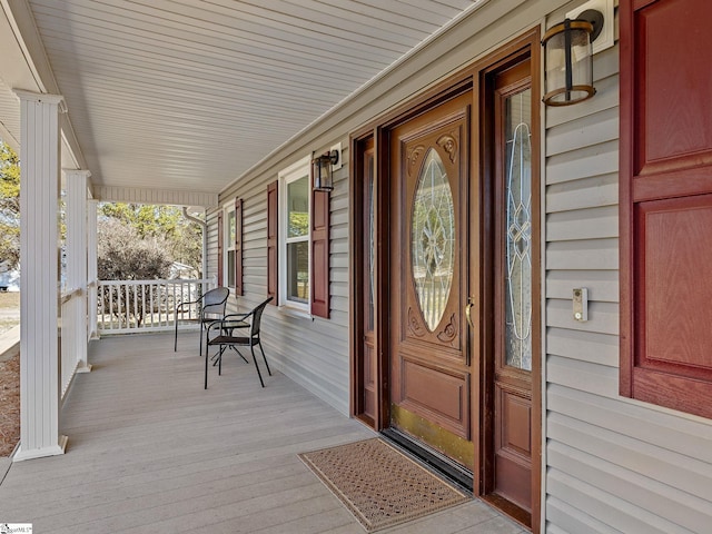 view of exterior entry featuring covered porch