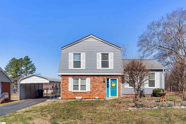 view of front of house featuring a carport, brick siding, driveway, and a front lawn