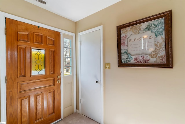 foyer featuring light carpet and visible vents