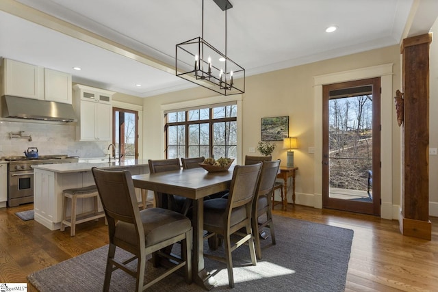 dining area with baseboards, ornamental molding, dark wood-type flooring, and a healthy amount of sunlight