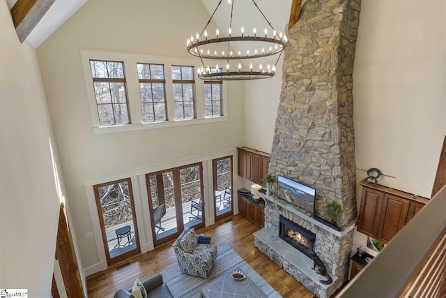 living room featuring high vaulted ceiling, a fireplace, and wood finished floors