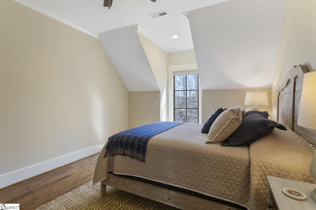 bedroom with ornamental molding, visible vents, baseboards, and wood finished floors