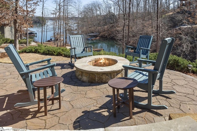 view of patio / terrace with a fire pit and a water view