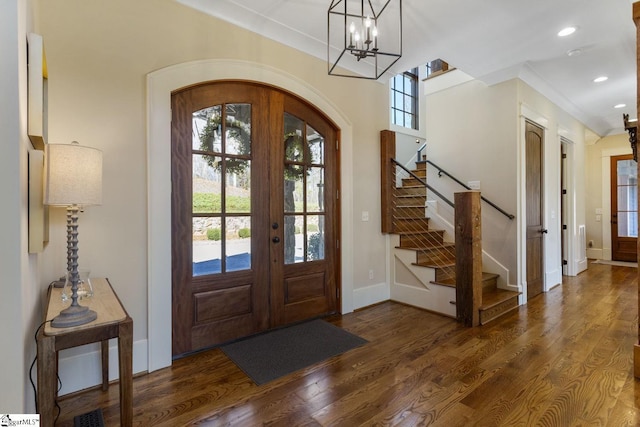 entrance foyer featuring arched walkways, wood finished floors, stairs, french doors, and recessed lighting