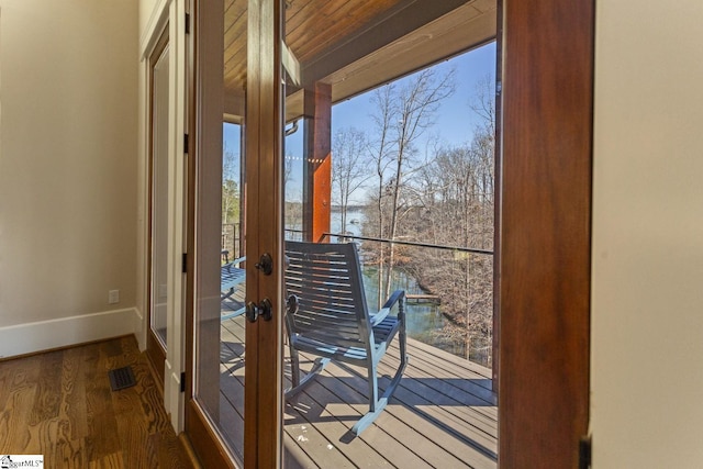 doorway with french doors, visible vents, baseboards, and wood finished floors