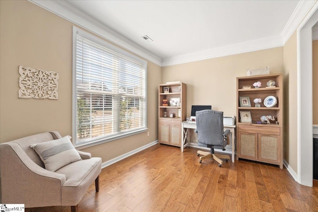 home office featuring baseboards, light wood finished floors, visible vents, and crown molding