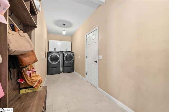 washroom with cabinet space, baseboards, and independent washer and dryer