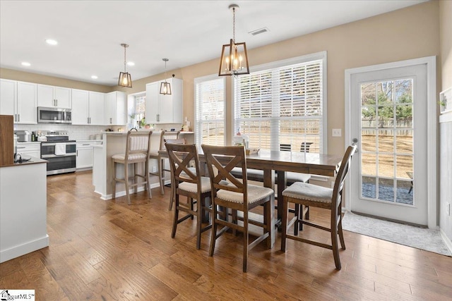 dining area with visible vents, wood finished floors, a wealth of natural light, and recessed lighting