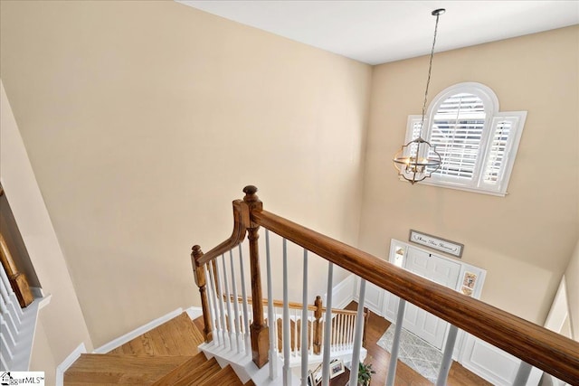 stairway with a notable chandelier and baseboards