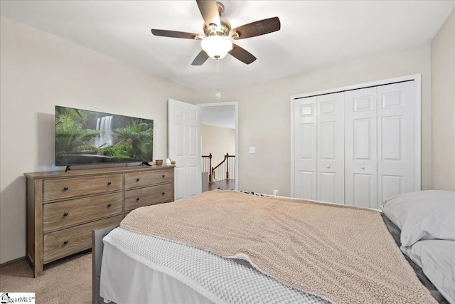 bedroom featuring a closet, light colored carpet, and ceiling fan