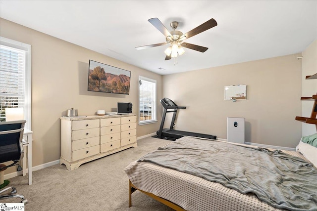 bedroom featuring a ceiling fan, light carpet, and baseboards