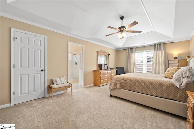 bedroom with light carpet, baseboards, ornamental molding, ensuite bathroom, and a tray ceiling