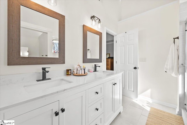 bathroom featuring tile patterned floors, a sink, baseboards, and double vanity