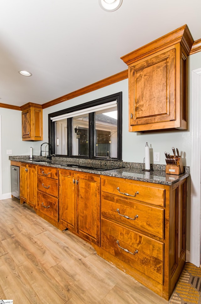 kitchen with brown cabinetry, light wood-style flooring, ornamental molding, stainless steel dishwasher, and a sink