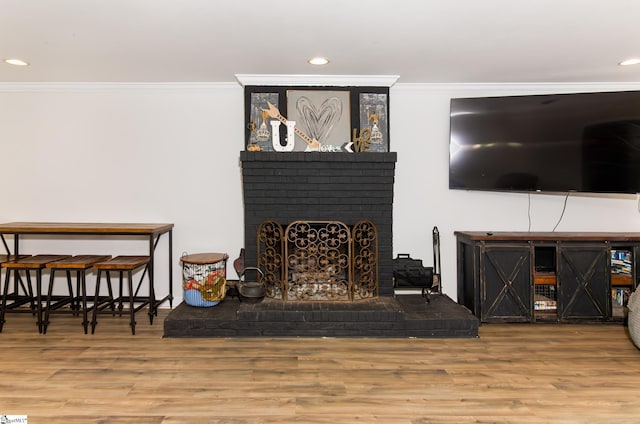 living area featuring ornamental molding and wood finished floors