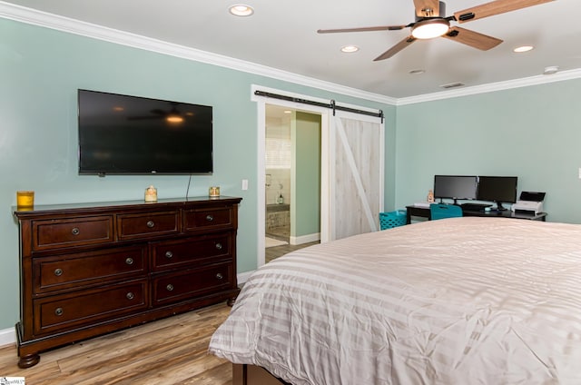 bedroom featuring a barn door, ornamental molding, and light wood-style flooring