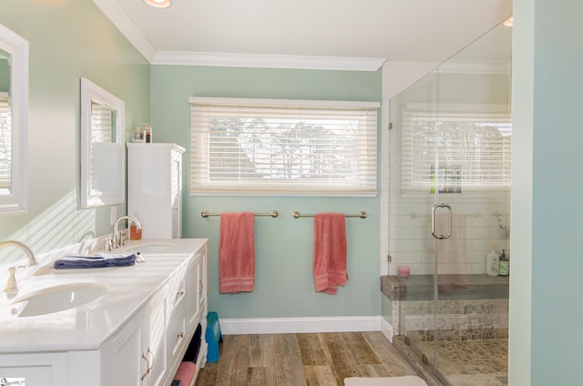 bathroom featuring crown molding, a sink, a shower stall, and wood finished floors