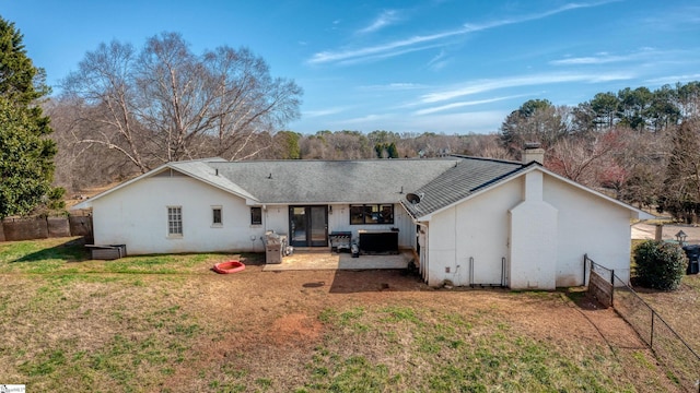 back of property featuring french doors, a patio area, a lawn, and fence