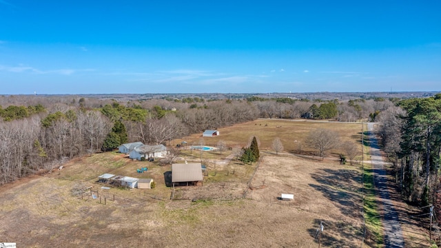 birds eye view of property featuring a wooded view and a rural view