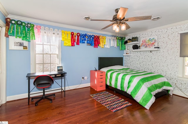 bedroom featuring baseboards, wood finished floors, visible vents, and crown molding