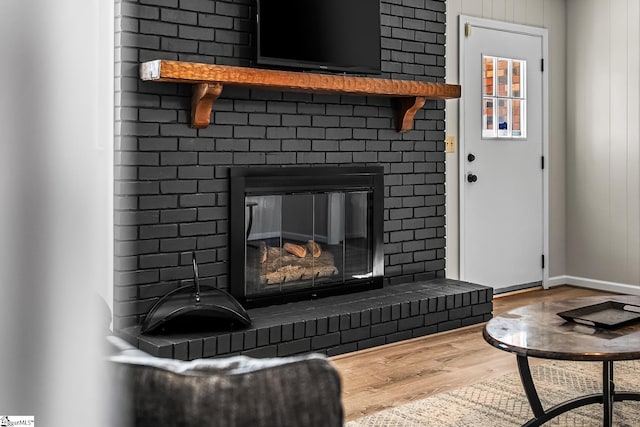 details with a brick fireplace, baseboards, and wood finished floors