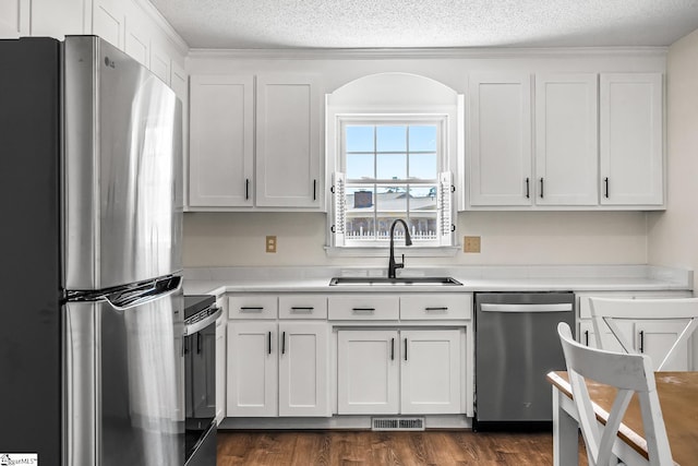 kitchen with visible vents, stainless steel appliances, a sink, and light countertops