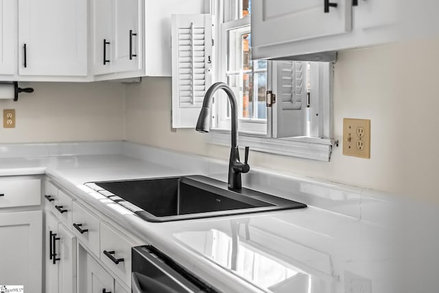 kitchen with white cabinets, a sink, and light countertops