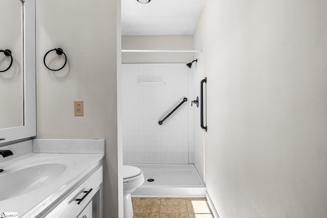 bathroom with toilet, a shower stall, tile patterned flooring, and vanity