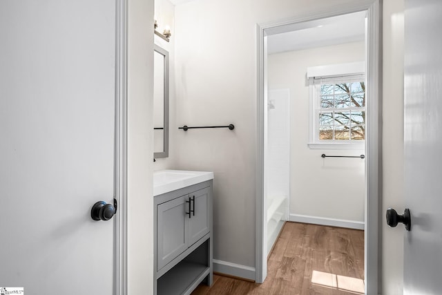 bathroom with wood finished floors, vanity, and baseboards