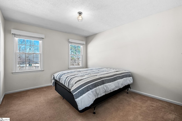 carpeted bedroom with baseboards and a textured ceiling