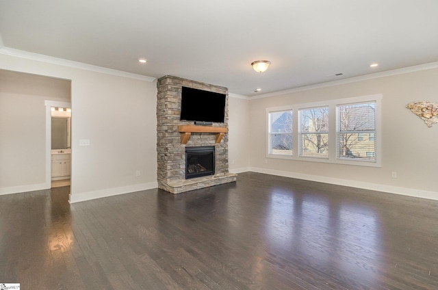 unfurnished living room with dark wood-style floors, a stone fireplace, baseboards, and crown molding