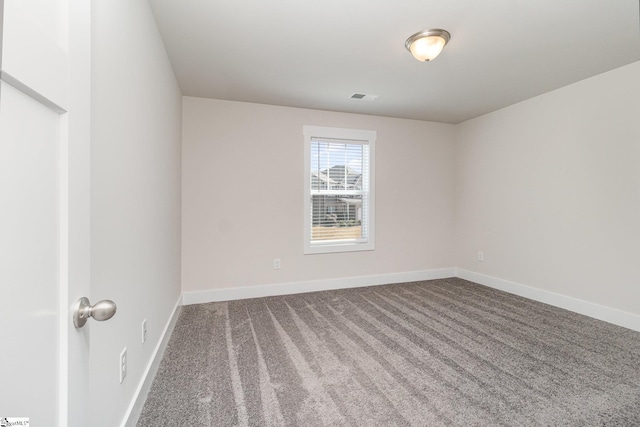 spare room featuring baseboards, visible vents, and carpet flooring