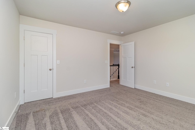 empty room featuring carpet floors and baseboards