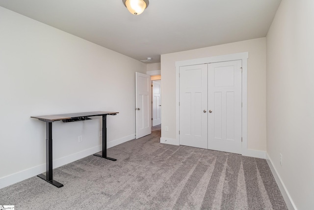 unfurnished bedroom with a closet, carpet flooring, and baseboards