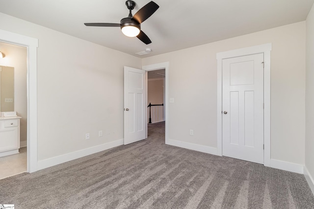 unfurnished bedroom featuring ensuite bathroom, carpet floors, and baseboards