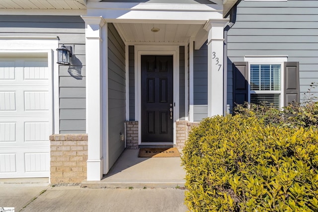 entrance to property with a garage and stone siding