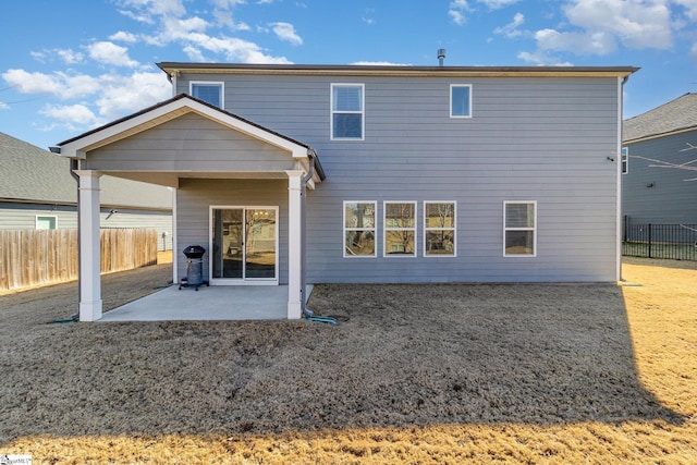 rear view of house with a patio area and fence