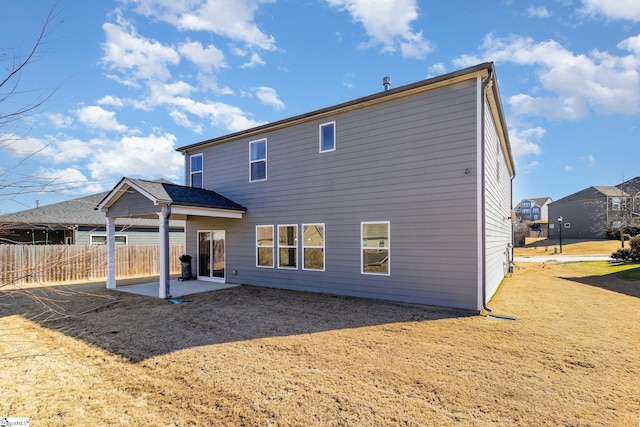 rear view of property featuring fence and a patio