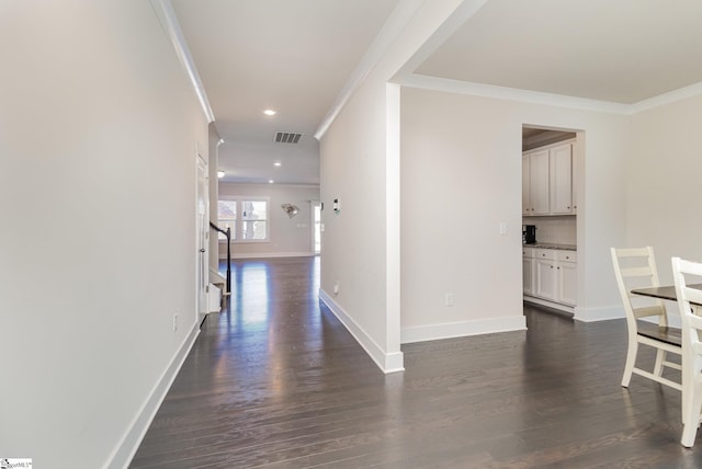 hall featuring baseboards, visible vents, dark wood-style floors, stairs, and crown molding