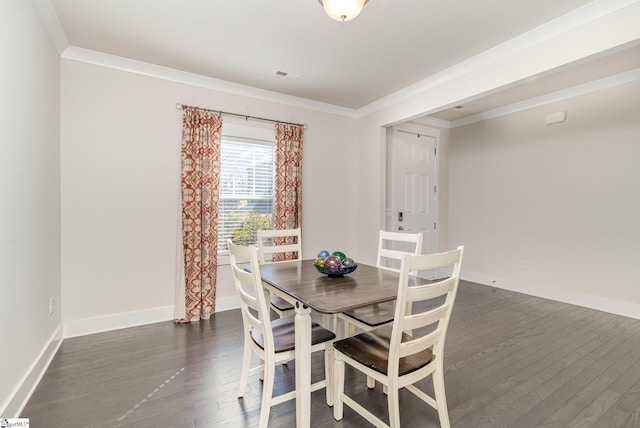 dining area featuring dark wood-style flooring, crown molding, and baseboards