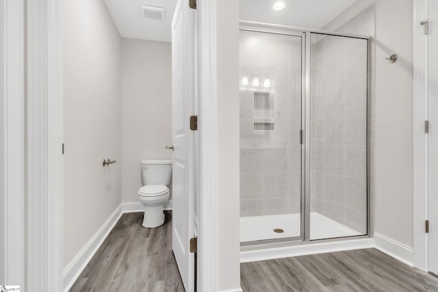 full bathroom featuring visible vents, toilet, a stall shower, wood finished floors, and baseboards