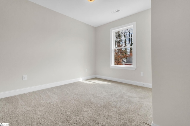 carpeted spare room featuring visible vents and baseboards