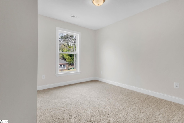 spare room with carpet, visible vents, and baseboards