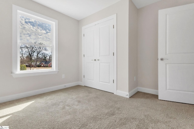 unfurnished bedroom featuring a closet, carpet, and baseboards