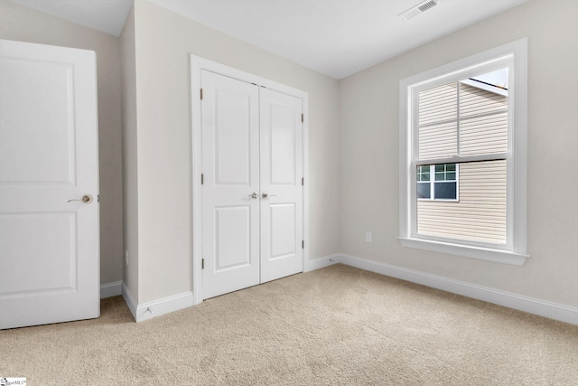 unfurnished bedroom featuring carpet floors, a closet, visible vents, and baseboards