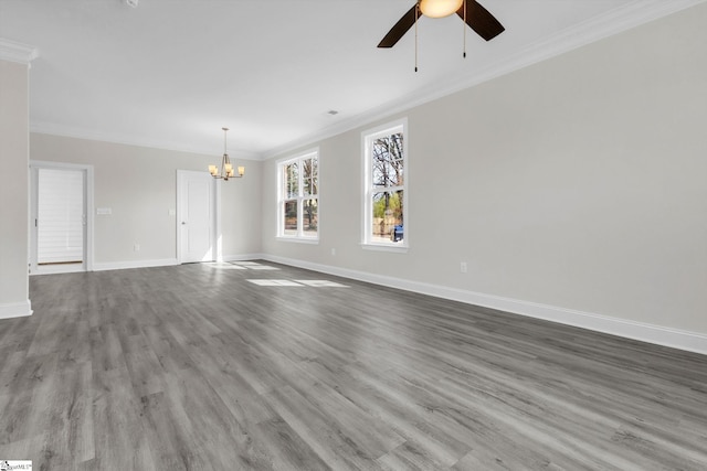 unfurnished room with ceiling fan with notable chandelier, ornamental molding, wood finished floors, and baseboards