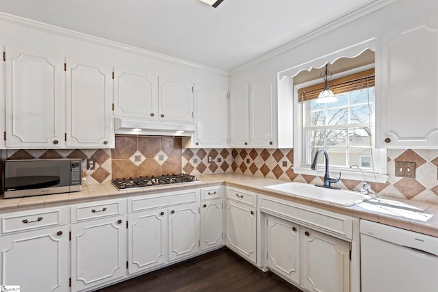 kitchen with under cabinet range hood, crown molding, a sink, dishwasher, and stainless steel gas stovetop