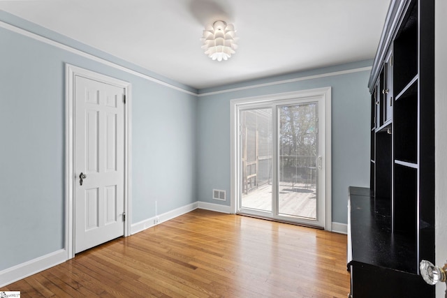 interior space with light wood finished floors, baseboards, and visible vents