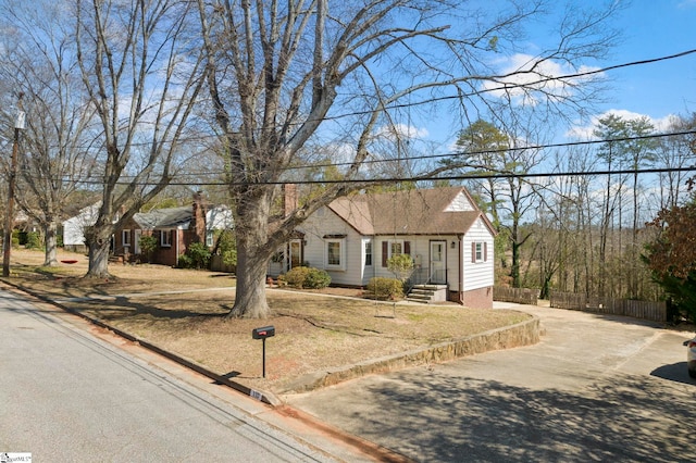 view of front of house with driveway, fence, and a front yard