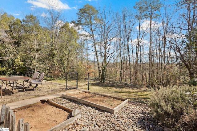 view of yard with a vegetable garden and a wooded view